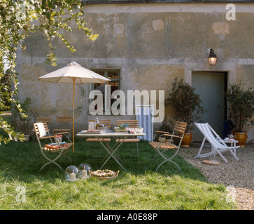 Parasol plus de meubles de jardin en bois à l'extérieur de maison de campagne traditionnelle Française Banque D'Images