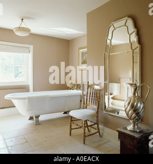 Baignoire sur pieds sur carrelage dans salle de bain pays, grand miroir sur le mur Banque D'Images