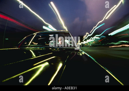 Voiture roulant dans les rues de la ville la nuit Banque D'Images