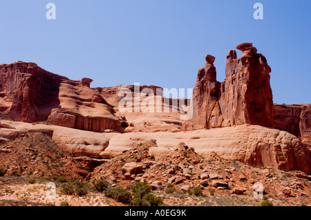 D'énormes tours de grès rouge et des falaises escarpées se dressent sous un ciel dégagé dans le parc national d'Arches, Moab, Utah. Banque D'Images