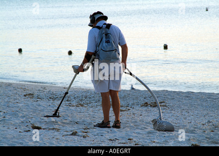 Bonita Springs beach Floride USA Beachcomber en utilisant un détecteur de métal sur la côte du golfe au coucher du soleil Banque D'Images