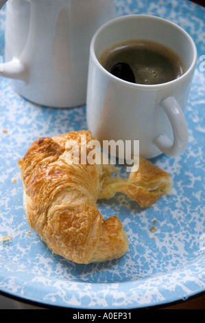 Du vrai café faite simplement dans la verseuse avec passoire du thé et un croissant Banque D'Images