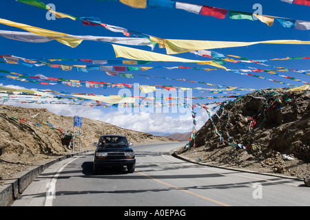 Les drapeaux de prières à travers la route à passe-haut Yamdrok 17860ft. Région autonome du Tibet en Chine Banque D'Images