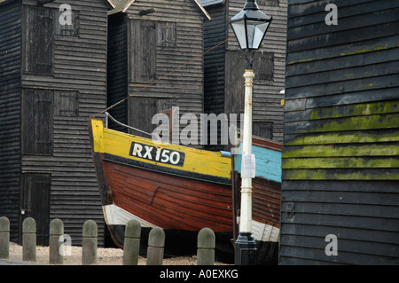 Net en bois abris et des bateaux de pêche au Stade, Hastings, Sussex, England, UK Banque D'Images