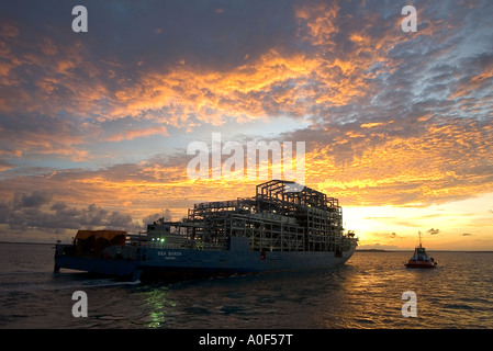 Le guidage d'un remorqueur dans le port pétrolier à l'aube Banque D'Images