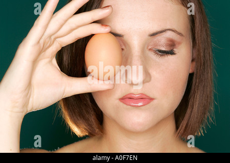 Woman holding egg Banque D'Images