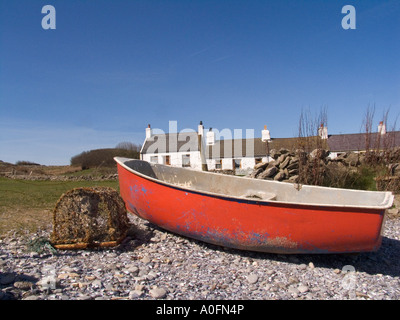 Llangefni ISLE OF ANGLESEY AU NORD DU PAYS DE GALLES UK Avril une barque rouge est sec, avec un vieux entartrés lobster pot Banque D'Images