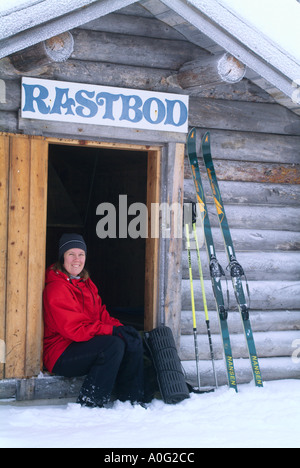 Femme assise à l'extérieur, chalet de ski en Suède. Banque D'Images