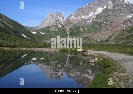 Les marcheurs reflète dans le Lac du Combal et vue de Lex Blanche près du Mont Blanc, Alpes Italiennes Banque D'Images