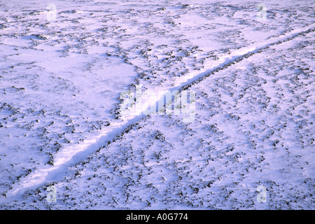 La piste couverte de neige fine un passage sur une colline par la zone utilisée pour le pâturage des moutons Banque D'Images