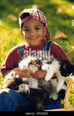 Portrait of a Boy holding cats Banque D'Images