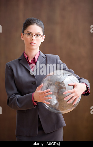 Businesswoman holding inflatable globe Banque D'Images