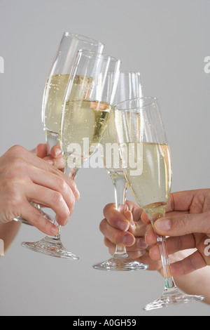 Groupe de mains toasting champagne flutes Banque D'Images