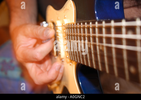 Un GROS PLAN D'UN HOMME JOUANT DE LA GUITARE Banque D'Images