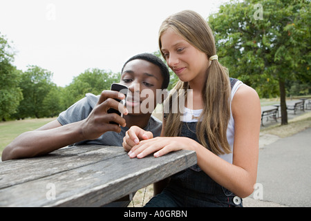 Teenage couple looking at cellphone Banque D'Images