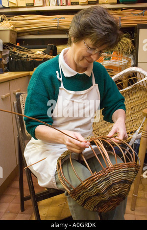 Femme dans son panier tressé en atelier Banque D'Images