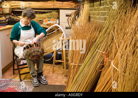 Femme dans son panier tressé en atelier Banque D'Images