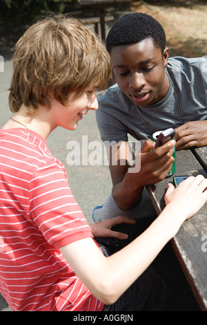 Les adolescents à la recherche de téléphone cellulaire Banque D'Images