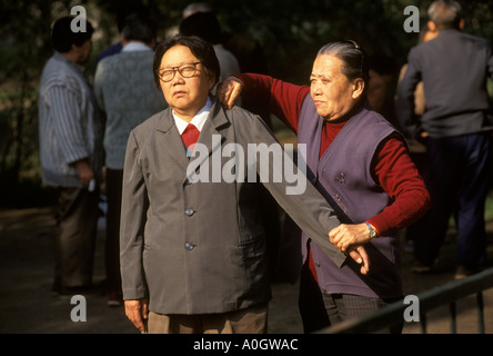 Parc Tiantan Beijing Chine années 1990. Femme donne un massage à un autre en 1998. HOMER SYKES Banque D'Images