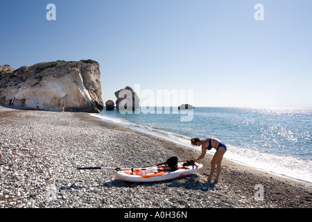 Un visiteur consulte ses petits CANOË SUR LA PLAGE. Au lieu AFRODITES CHYPRE Banque D'Images