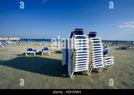 Transats SUR LA PLAGE EN FACE DE LA VILLE DE LARNAKA BOUTIQUES ET RESTAURANTS CHYPRE Banque D'Images