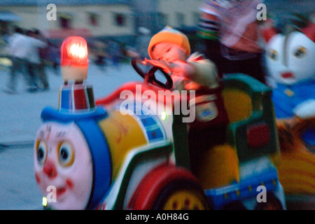 L'enfant essaie de braquer kiddie train à Xinjie village la nuit, Yuanyang, Yunnan, Chine (flou de mouvement) Banque D'Images