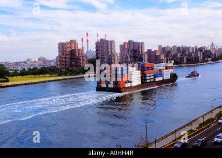 New York City, East River, barge pour bateaux à conteneurs, arnaque et bateau à vapeur passant sur East River Drive, (FDR Drive), Queens et Upper East Side Manhattan. Banque D'Images