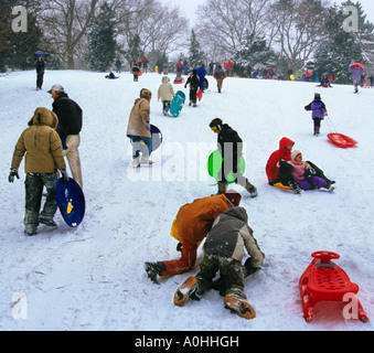 Activités d'hiver dans le parc central de New York. Scène de neige avec des foules d'enfants qui traînent sur Cedar Hill. New York, Central Park Conservancy. ÉTATS-UNIS Banque D'Images