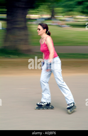 Une femme le roller dans Hyde Park à Londres. Banque D'Images