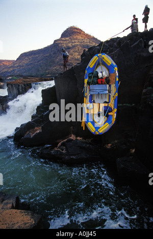 Guides de Rafting radeaux et équipements de portage ci-dessous Mowenba Falls sur la rivière Zambèze, l'Afrique Banque D'Images