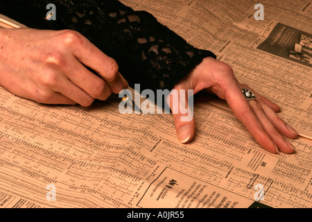 Woman picking stocks et des actions dans le Financial Times Banque D'Images