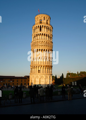 Les touristes regardant la célèbre tour Torre Pendente glow spectaculaire dans la dernière lumière du soleil Pise Toscane Italie Banque D'Images