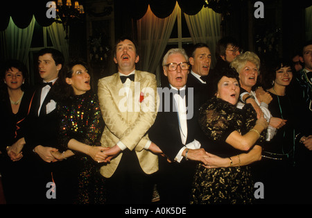 Auld Lang Syne UK. Groupe de personnes de groupe de la Saint-Sylvestre invités au Ritz Hotel chantant. Bras dans les bras réunis, Londres Angleterre années 1986 1980 HOMER SYKES Banque D'Images