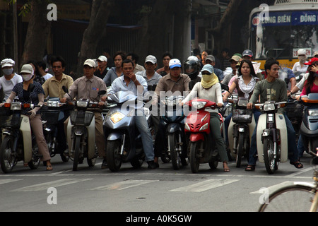 Les cyclomotoristes attendent les lumières de changer dans le centre de la ville de Hanoi, Vietnam Banque D'Images