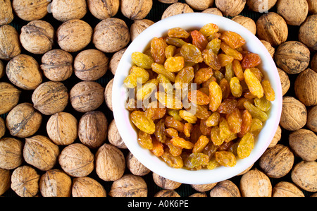 Les raisins secs dans le bol et noix Banque D'Images