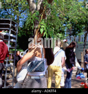 Femme transportant à Columbia Road Market à Hackney Tower Hamlets East London E2 UK KATHY DEWITT Banque D'Images