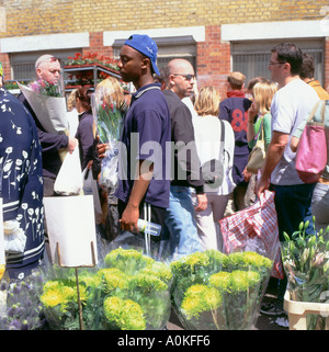 Les personnes à la recherche d'affichage en cale au Columbia Road Flower Market Shoreditch Tower Hamlets London UK Banque D'Images