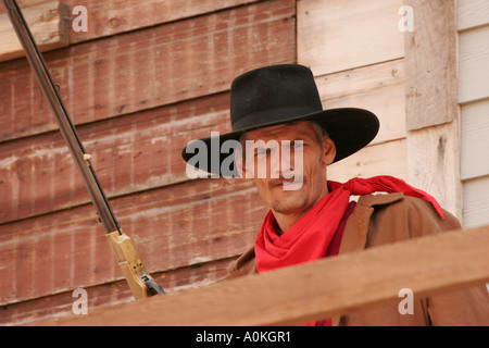 Un cowboy avec une arme à feu sur un balcon de l'ancien bâtiment au cours reenactment Banque D'Images