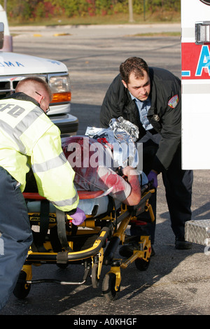 Techniciens d'urgence sont le chargement d'une victime sur un brancard pour aller dans une ambulance Banque D'Images