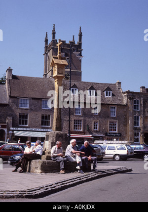 Le temps de s'asseoir autour de la ville de Cotswold Bourton on the water à côté de croix en pierre sur la place du marché Banque D'Images