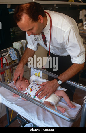 Un médecin avec un bébé prématuré dans l'unité de soins néo natal un hôpital de Londres, UK Banque D'Images