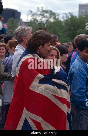 Un couple aimant enveloppé dans une Union Jack à l'extérieur de Buckingham Palace à la célébration du Jubilé de Londres en juin 2002 Banque D'Images