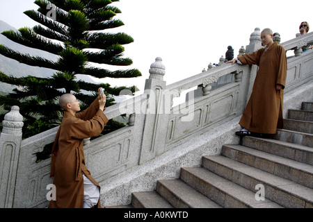 Une religieuse prend une photo d'une autre nonne en face de la Place Tian Tan Buddha, Lantau Island, Hong Kong Banque D'Images