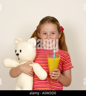 Girl holding teddy et verre de jus Banque D'Images