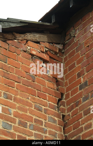 Bâtiment ancien de ferme construit en briques rouges sur un sol argileux vue extérieure rapprochée sur le toit de la fissure majeure de la colonie à la jonction de 2 deux murs Essex Angleterre Royaume-Uni Banque D'Images