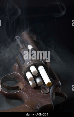 Vieux pistolet revolver rouillé avec des cigarettes chargé dans le vérin et un incendie Banque D'Images