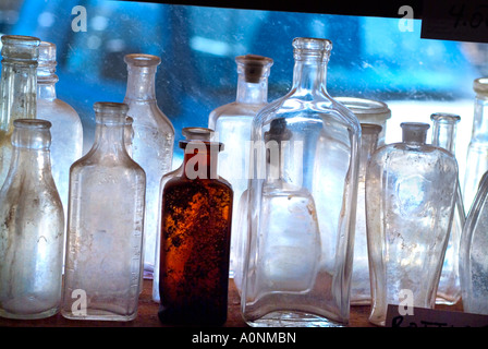 Vieux flacons de médicaments anciens restaurés assis sur un rebord de fenêtre avec rétroéclairage Banque D'Images