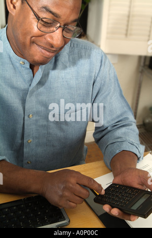 L'homme à l'aide de la calculatrice, smiling Banque D'Images