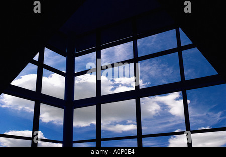 Ciel bleu et nuages vus à travers la fenêtre Grille de bâtiment moderne Banque D'Images
