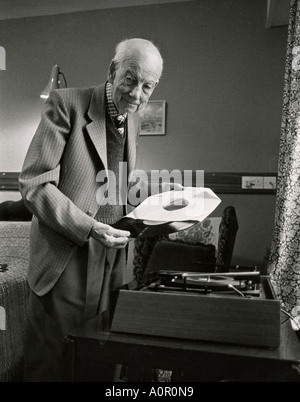 Un homme âgé à l'intérieur avec de vieux gramophone et enregistrement. Banque D'Images